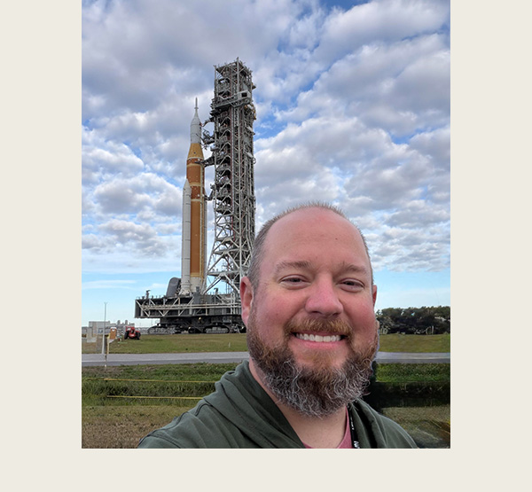 Jeff Triplett stands in front of the Artemis II rocket during the initial rollout in January.