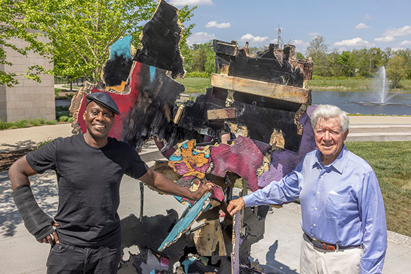 Artist Leonardo Drew and donor Tom Smith '50 in front of Drew's sculpture