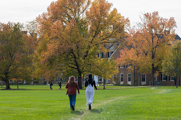 two students walk on central quad toward Macmillan hall