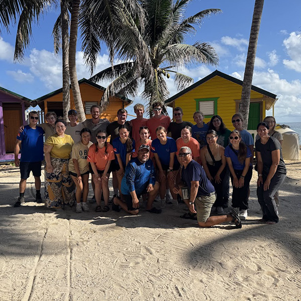 Twenty first-year Honors College students pose for a final group photo with instructors Erin Wahler and Jill Korach and their Belizean hosts on Tobacco Caye (photo courtesy of Erin Wahler).