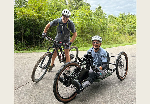 yoshi tomoyasu on a handcycle and another man on a bicycle