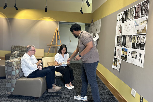 May Khalife, center, talks with a Miami University graduate student, right.
